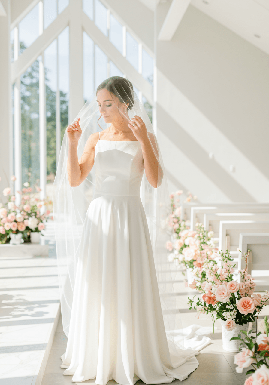 Bride adjusting veil in bright modern chapel with clean geometric architecture