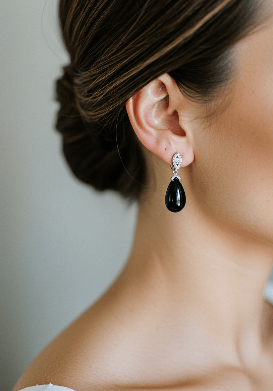 Elegant black onyx teardrop earrings in white gold with diamond accents worn by bride with sleek chignon