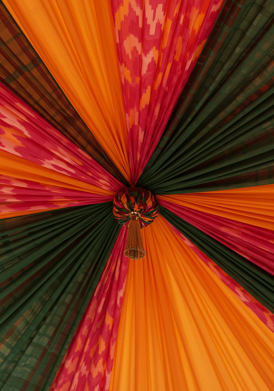 Ornate tent ceiling with twisted orange ikat and hunter green plaid fabric gathering points